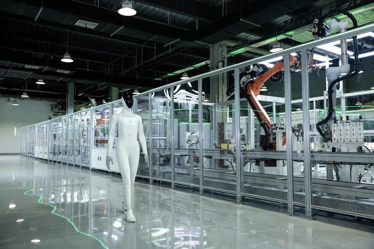 XPeng's IRON humanoid robot walking past the automated production line at the company's newly commissioned humanoid robot facility