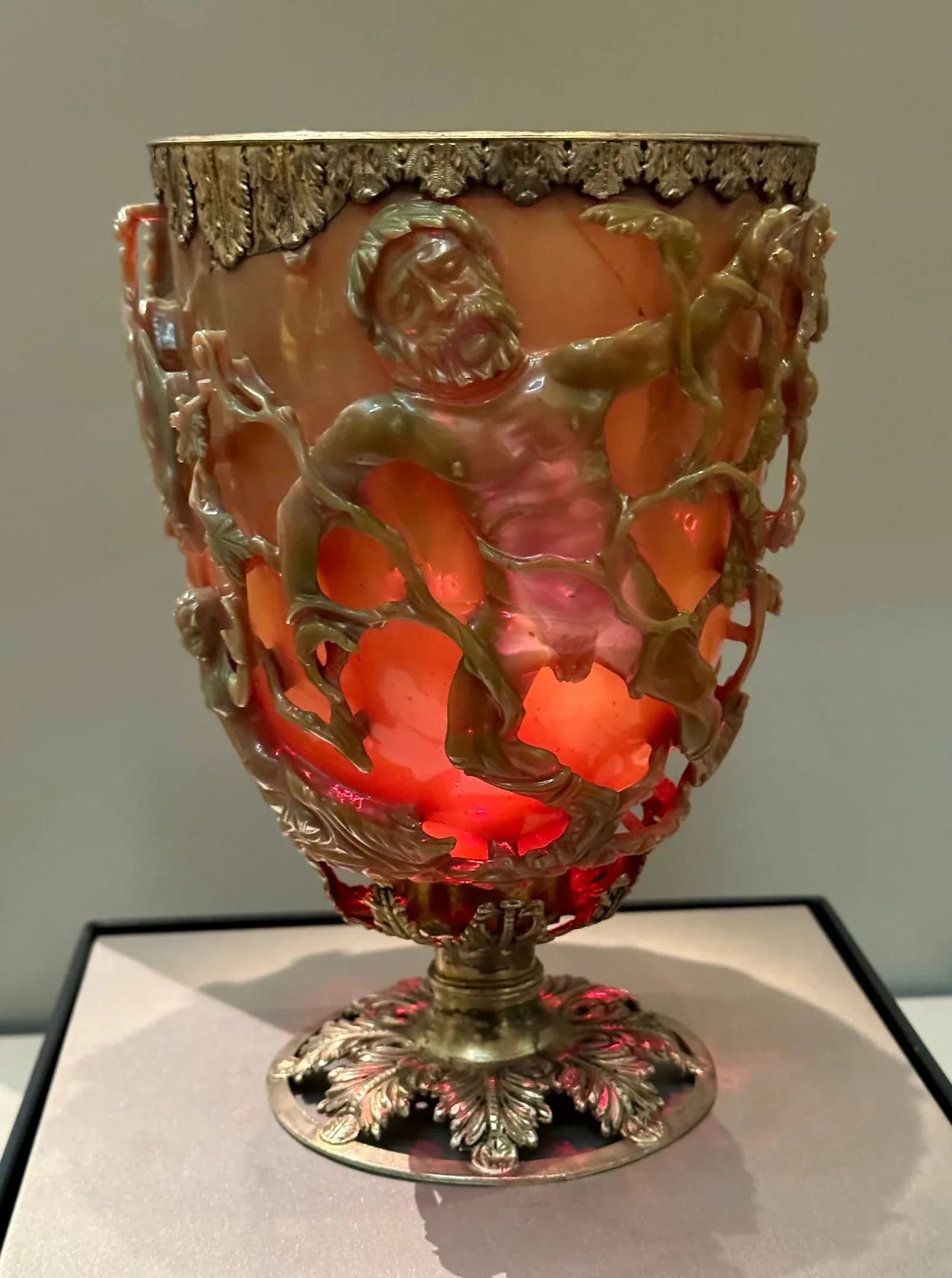 The Roman Lycurgus Cup in the British Museum, lit from behind so its glass glows ruby red.