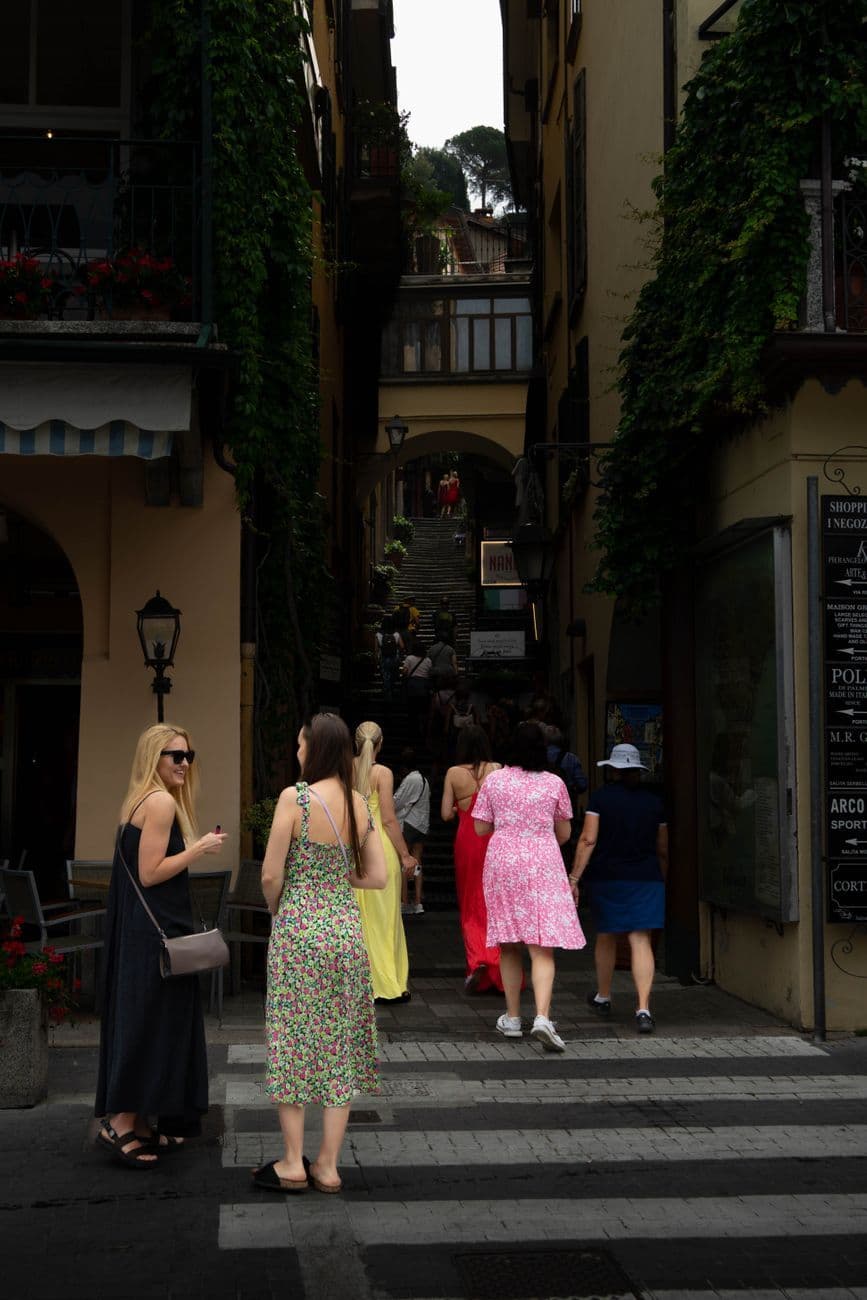 A lively scene of tourists walking through Bellagio, Italy's picturesque streets.