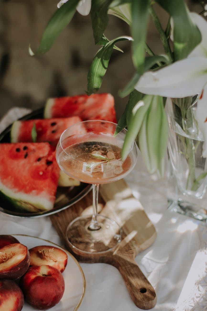A stylish outdoor setup with watermelon slices and a refreshing drink, perfect for summer vibes.
