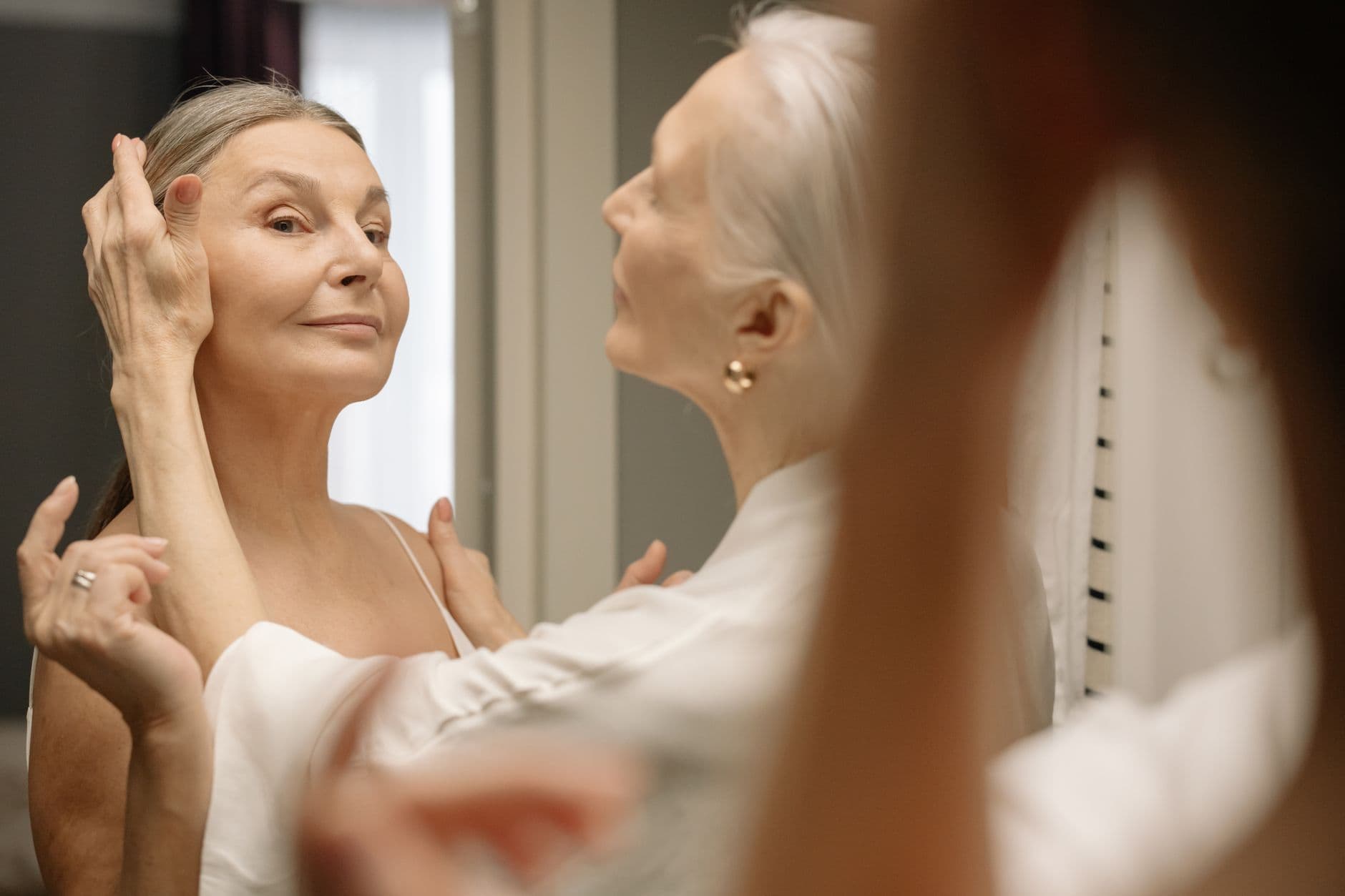 Chic elderly woman applying makeup, embracing beauty and confidence at any age.