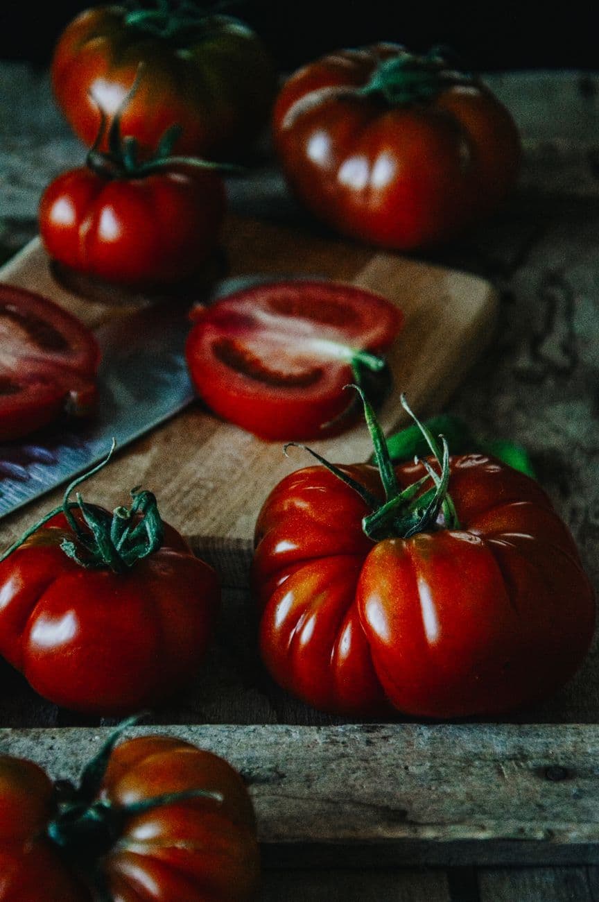 High-quality heirloom tomatoes on a rustic wooden table, showcasing their rich color and texture.