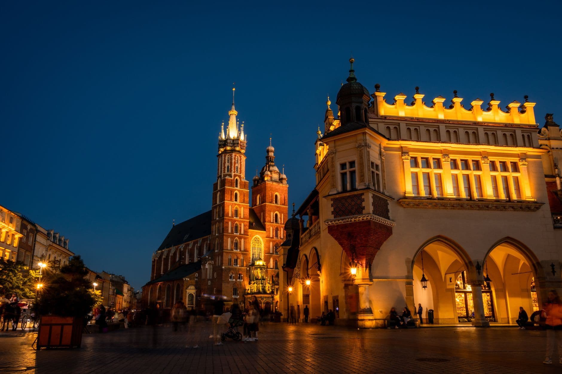 Vibrant nighttime shot of St. Mary's Basilica and Cloth Hall in Krakow's Main Square.